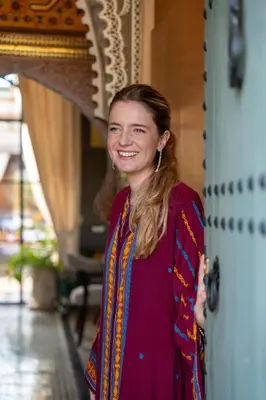 a woman is smiling while standing next to a door at Daba Riads in Marrakech