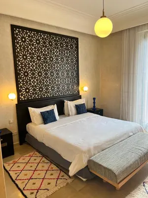 a bedroom with a large bed and a large wall at Villa kasbah de luxe, piscine et jacuzzi chauffés, jardin tropical in Marrakech
