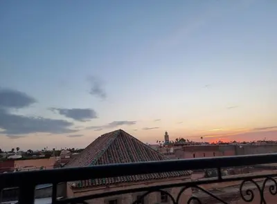 a view of the pyramids from a balcony at sunset at amazing home and amazing rooftop in Marrakech