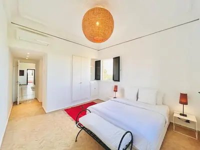 a white bedroom with a bed and a lamp at Villa Zaria Marrakech Heated Pool Family Friendly 25 Min To Medina in Marrakech