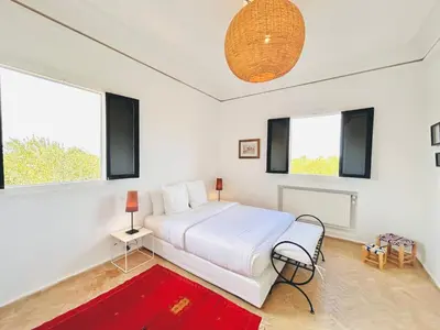 a bedroom with a white bed and two windows at Villa Zaria Marrakech Heated Pool Family Friendly 25 Min To Medina in Marrakech
