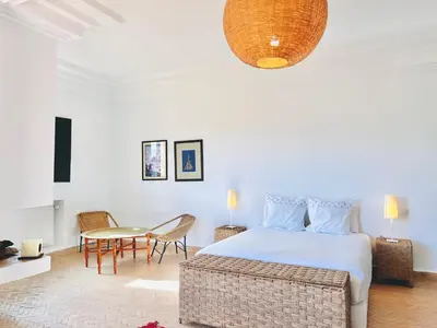 a bedroom with a bed and a table and chairs at Villa Zaria Marrakech Heated Pool Family Friendly 25 Min To Medina in Marrakech