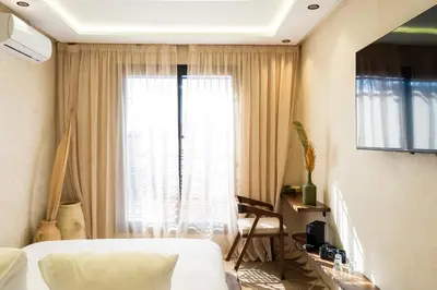 a bedroom with a bed and a large window at Suite cosy en hypercentre in Marrakech