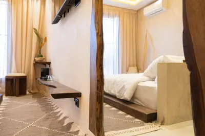 a bedroom with a bed and a mirror in it at Suite cosy en hypercentre in Marrakech