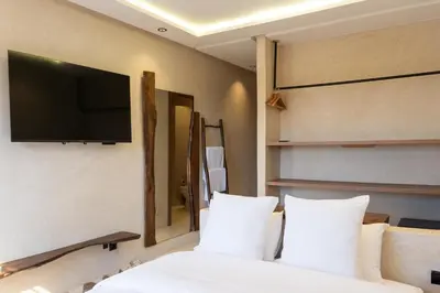 a bedroom with a bed with a flat screen tv on the wall at Suite cosy en hypercentre in Marrakech
