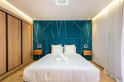 a bedroom with a large bed with a blue headboard at Studio Ali gueliz in Marrakech