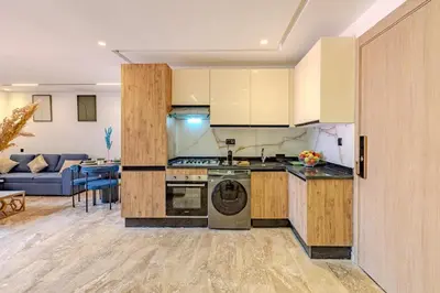 a kitchen with a stove top oven next to a living room at Studio Ali gueliz in Marrakech