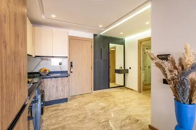 a kitchen with white cabinets and a vase with a plant at Studio Ali gueliz in Marrakech