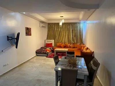 a living room with a couch and a table at l'évasion 8 face gare CTM Hivernage a 10mn de l'aéroport in Marrakech