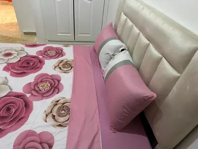 a pink jacket on a bed with flowers on it at l'évasion 8 face gare CTM Hivernage a 10mn de l'aéroport in Marrakech
