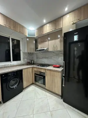 a kitchen with a washer and dryer in it at Séjour haut de gamme lit king TV cinéma 65 in Marrakech