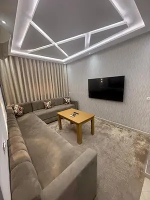 a living room with a couch and a flat screen tv at Séjour haut de gamme lit king TV cinéma 65 in Marrakech