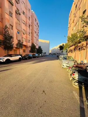 a street with cars parked on the side of the road at Séjour haut de gamme lit king TV cinéma 65 in Marrakech