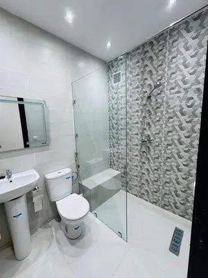 a bathroom with a shower and a toilet and a sink at Séjour haut de gamme lit king TV cinéma 65 in Marrakech