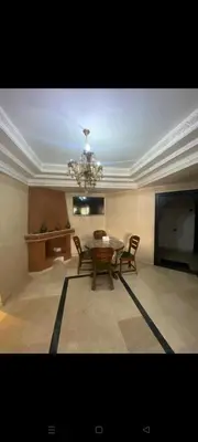 a dining room with a table and chairs and a chandelier at Riad jawhara in Marrakech