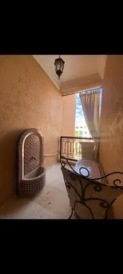 a room with a balcony with a table and a window at Riad jawhara in Marrakech