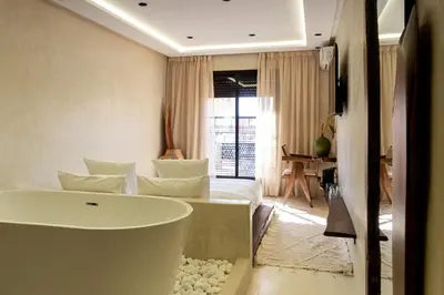 a bathroom with a tub and a bed in a room at Suite luxueuse avec baignoire ouverte in Marrakech