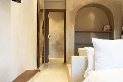 a bedroom with a white bed and a door at Suite luxueuse avec baignoire ouverte in Marrakech