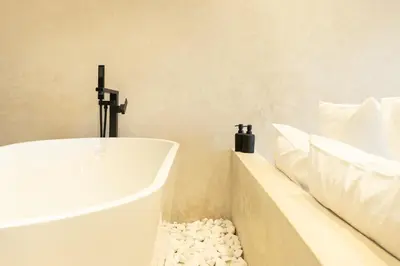 a white bath tub in a bathroom with pillows at Suite luxueuse avec baignoire ouverte in Marrakech