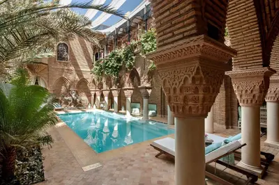a large swimming pool in a building with trees at rid kalim in Marrakech