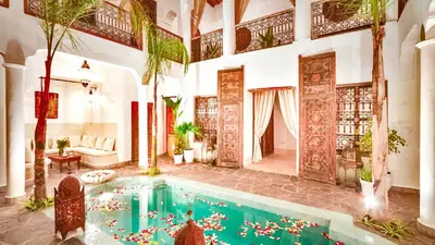 an indoor pool in a house with flowers in the water at rid kalim in Marrakech