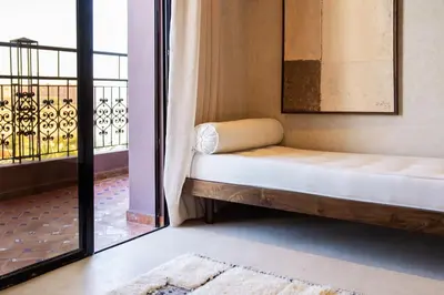 a bed in a room next to a balcony at Suite avec vue époustouflante sur les jardins majorelle in Marrakech