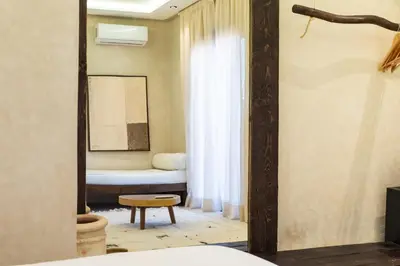 a room with a bed and a window with a tub at Suite avec vue époustouflante sur les jardins majorelle in Marrakech