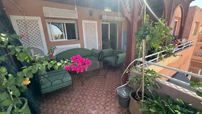 a balcony with green chairs and flowers and plants at Gueliz Boutique Apartment in Marrakech