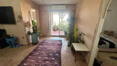 a living room with a door and a room with plants at Gueliz Boutique Apartment in Marrakech