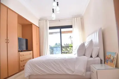 a bedroom with a white bed and a window at Ideal family apartment in Marrakech