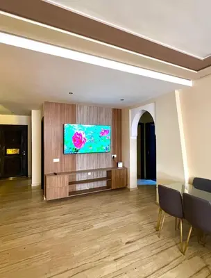 a living room with a television on a wall at L'Escapade Douce Marrakech in Marrakech