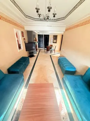 a living room with blue couches and a television at D13 Confortable A Riad Jawhara & Piscines in Marrakech