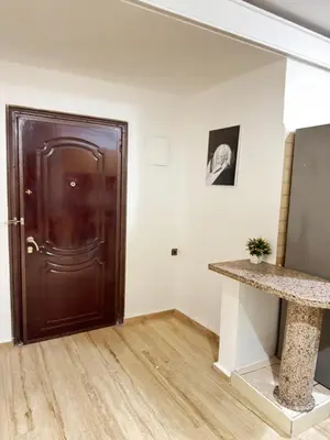 a brown door in a white room with a wooden floor at le numéro 7 in Marrakech