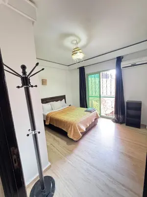 a bedroom with a bed and a large window at le numéro 7 in Marrakech
