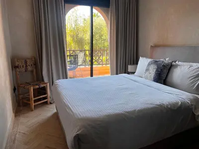 a bedroom with a bed and a large window at Your Getaway Oasis in the Lush Resort in Marrakech
