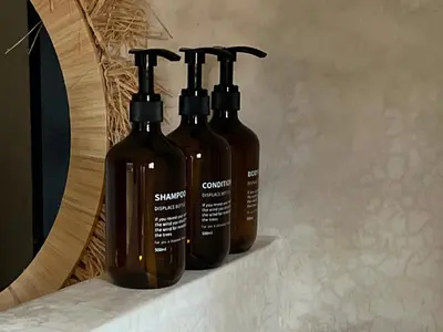 three bottles sitting on a counter next to a mirror at Your Getaway Oasis in the Lush Resort in Marrakech