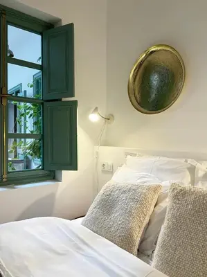 a bedroom with a bed with green cabinets and a window at Riad Les 3J in Marrakech