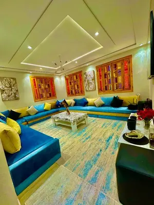a living room with a blue couch and a table at المحاميد 10 in Marrakech