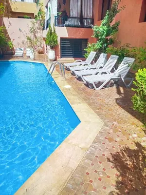 a swimming pool with lounge chairs next to a building at Résidence Jasmin 2 Marrakech Gueliz in Marrakech