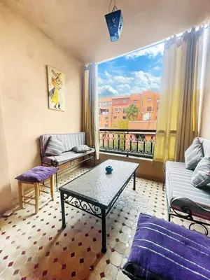 a living room with a couch and a table and a window at Résidence Jasmin 2 Marrakech Gueliz in Marrakech