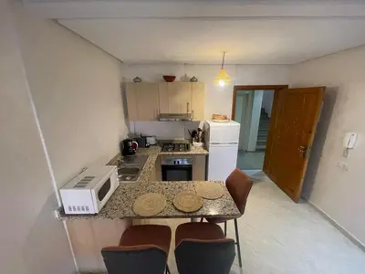 a small kitchen with a counter top with a microwave at Résidence Jasmin 2 Marrakech Gueliz in Marrakech