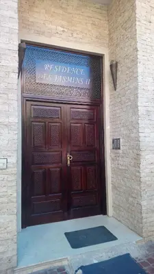 a large wooden door with a sign on it at Résidence Jasmin 2 Marrakech Gueliz in Marrakech
