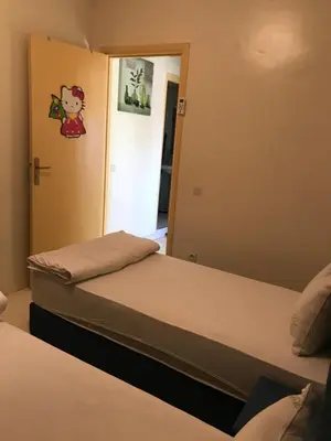 two beds in a room with a mirror at Appartement Simouni in Marrakech