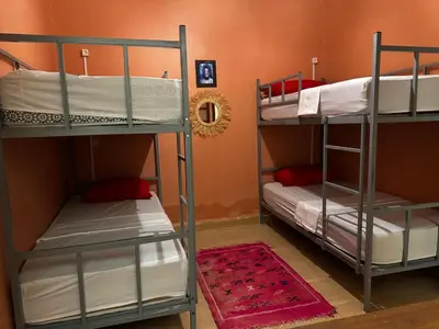 two bunk beds are in a room with an orange wall at Riad dar Malak in Marrakech