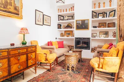 a living room with yellow furniture and a fireplace at Riad Dar Dounia in Marrakech
