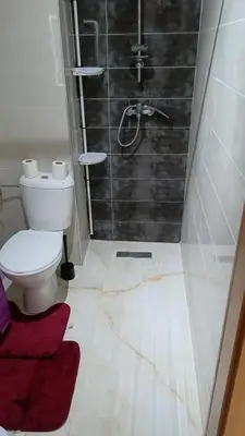 a bathroom with a shower with a toilet and a sink at Mountazah al jadid H22 in Marrakech