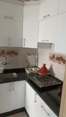 a kitchen with a stove with a red pot on it at Mountazah al jadid H22 in Marrakech