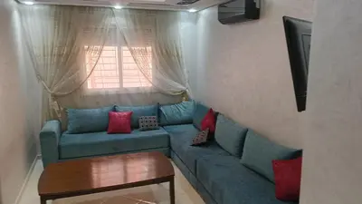 a living room with a blue couch and a window at Mountazah al jadid H22 in Marrakech