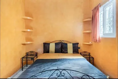 a bedroom with a bed with two chairs and a window at Riad Golden Palm in Marrakech