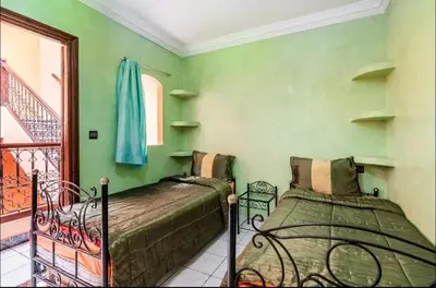 a bedroom with two beds and a balcony at Riad Golden Palm in Marrakech